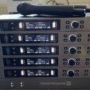 Šest stohovaných rackových přijímačů značky beyerdynamic v stříbrném provedení. Každé zařízení má nápis TG 1000, dva digitální displeje s údaji o kan…