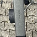 Detailní pohled na šedý kovový prvek stativu s černými plastovými knoflíky. Na boku je vyražen nápis Made in Germany. Povrch materiálu je matný a vyk…