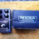 Modrý kytarový efekt s nápisy MESA ENGINEERING a FLUX-DRIVE. Na horní straně jsou čtyři ovládací knoflíky s popisky BASS, LEVEL, TREBLE a GAIN. Pod e…