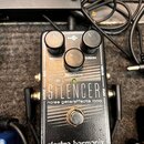 Černý efekt pedál s nápisy THE SILENCER a noise gate/effects loop. Na horní části jsou tři ovládací knoflíky s popisky RELEASE, REDUCTION a THRESH, u…