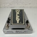 Stříbrný efekt pedál s černým nášlapem, na kterém je bílý nápis MORLEY®. Na spodní části šasi jsou nápisy FUZZ, WAH a text Cliff Burton Tribute Serie…
