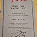 Fotografie znázorňuje certifikát pravosti (CERTIFICATE OF AUTHENTICITY) značky Fender. Dokument obsahuje text „'48 DUAL PROFESSIONAL" JB EDITION“ a r…