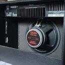 Zadní strana černého kytarového komba značky LINE 6 s otevřeným zadním panelem. Uvnitř je viditelný reproduktor s nápisem CELESTION CUSTOM DESIGN, dá…