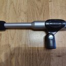 Stříbrný mikrofon s černou pěnovou clonou na konci. Na černém plastovém držáku je vyryt nápis G20-p30mm. Povrch mikrofonu i držáku je v dobrém stavu…