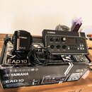 Na fotografii je elektronický modul pro akustické bubny Yamaha EAD10 v originální krabici. Modul je černý, s ovládacími knoflíky Volume, Master, Audi…