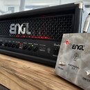 Černý kytarový zesilovač s kovovou mřížkou a nápisem ENGL. Na předním panelu jsou ovládací knofíky, přepínače a nápisy včetně modelu Fireball. Před z…
