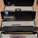 Tři kusy lištových harmonik v černých plastových pouzdrech. Na kovovém krytu každého nástroje je vyražen nápis TOMBO HARMONICA 21. Povrchy nástrojů v…