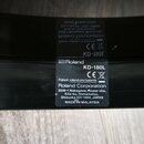 Fotografie detailu černé plochy s nalepeným informačním štítkem. Na štítku je bílý nápis Roland, označení modelu KD-180L a symbol CE. Dále je uveden…