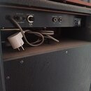 Zadní panel černého kytarového komba s ovládacími prvky a konektory. Jsou zde nápisy AC OUTLET, POWER FUSE, HEAD PHONE, LINEOUT a označení MAX. 200W…
