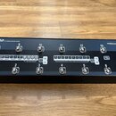 Černý kytarový spínací systém s nápisem G2 THE ADVANCED SWITCHING SYSTEM a logem theGIGRIG.com v pravém horním rohu. Zařízení má 14 kovových spínačů…