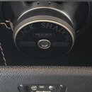 Fotografie zachycuje reproduktor v černém kabeletu s nápisy BLACK SHADOW, MESA ENGINEERING a CELESTION. Pod reproduktorem je vidět kovový konektor s…
