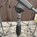 Detailní záběr na šedý kovový stojan s černými plastovými prvky. Na trubicích je vidět nápis KONIG & MEYER STARLINE. Povrch kovu vykazuje drobné škrá…