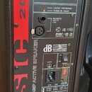 Zadovávací panel aktivního reproduktoru s červeným a šedým pozadím. Je zde uveden nápis BASIC 200, BASIC SERIES a BI-AMP ACTIVE SPEAKER spolu s logem…