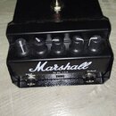 Černý efekt pedál s nápisem Marshall. Na horní straně je stomečový spínač a červená kontrolka, v přední části pět ovládacích knoflíků. Dole jsou vstu…