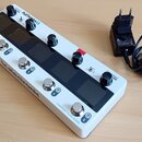 Bílý efektový pedál s pěti stoupacími spínači a čtyřmi otočnými knoflíky. Na horní části je nápis EFFECT PLETHORA X5 a v dolní části TONEPRINT PEDALB…