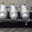 Pět stříbrných kovových reflektorů umístěných v černém přepravním kufru s modrým vnitřním polstrováním. Svítidla vykazují známky opotřebení, povrch j…
