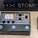 Černý efektový pedál Line 6 HX STOMP s kovovým šasi v texturovaném povrchu. Na horní straně je displej, tři ovládací knoflíky a čtyři tlačítka s nápi…