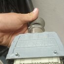 Šedý vícepinový konektor s kovovým tělem a plastovými kontakty uvnitř. Na horní části je vyražen nápis Vieland. Kabel je připojen pomocí kovové spojk…