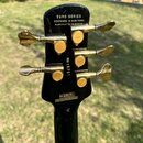 Zadní strana hlavy černé basové kytary se zlatými ladicími kolíky. V horní části je bílý nápis EURO SERIES, DESIGNED IN NEW YORK, HANDCRAFTED IN EURO…
