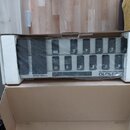 V polystyrenovém obalu v kartonové krabici se nachází MIDI kontrolér s řadou černých spínačů, zabalený v průhledné plastové fólii. Na spodní liště je…