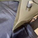 Detailní pohled na roh těla elektrické kytary v olivově zelené barvě s glossy povrchem. Na těle jsou vidět dva chromované knofíky s rýhovaným povrche…