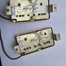 Dvě elektrické snímače typu humbucker v kovovém, zlatavém provedení. Na spodní straně obou snímačů jsou bílé nálepky s nápisy „IIHS 20160928“ a u hor…