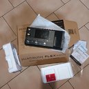 Na kartonové krabici s nápisem HEADRUSH FLEX PRIME THE MOST POWERFUL GUITAR FX/AMP MODELER leží černý kytarový procesor s nápisem HEADRUSH. Vedle zař…