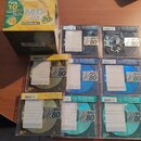 Fotografie zobrazuje sadu MiniDisc disků v plastových obalech a jednu kartonovou krabici. Na krabici je nápis Pack 10, MD Extra High Digital Grade 80…