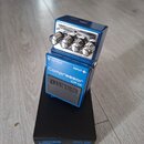 Modrý kompresorový pedál s nápisy Compressor CP-1X a logem BOSS. Na horní části jsou čtyři ovládací knoflíky s popisky SUSTAIN, ATTACK, RATIO a COMP.…