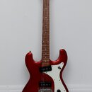 Elektrická kytara s červeným metalickým povrchem těla a hnědým hmatníkem. Na hlavě je bílý nápis "Cort". Kytara má bílý pickguard, jeden snímač typu…