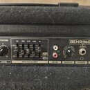 Detail ovládacího panelu basového komba značky BEHRINGER. Panel obsahuje nápisy BASS WORKSTATION, SHAPE, LEVEL, FBQ EQUALIZER s pětipásmovým ekvalizé…