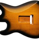 Tělo elektrické kytary s barevným přechodem od žluté v centru po černou na okrajích (sunburst). V dřevě je vyfrézovaný prostor pro zapojení elektroni…