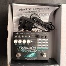 Stompbox efekt pedál v barvě stříbrné s nápisy OCEANS 12 DUAL STEREO REVERB a electro-harmonix NEW YORK CITY, USA. Zařízení obsahuje několik ovládací…