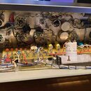 Fotografie zachycuje vnitřní pohled do šasi elektronického zařízení s rozvedením kabelů a komponentů. Jsou vidět různé kondenzátory, rezistory, poten…