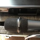 Černý dynamický mikrofon s mřížkou a nápisem e 845. Vedle něj je umístěn černý přijímač se značkou SENNHEISER a označením ewD1 Digital, který obsahuj…