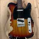 Elektrická kytara typu Telecaster s dřevem v přirozené barvě a tmavě hnědým, nepravidelným „spáleným“ vzorem. Má černý pickguard a jeden snímač u mos…