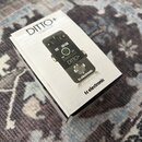 Bílá krabice s produktem tc electronic DITTO+ LOOPER. Na krabici je zobrazen černý pedál s nápisy DITTO+ LOOPER a tc electronic. V dolní části krabic…