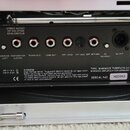 Záběr na zadní panel černého zesilovače s řadou konektorů a ovládacích prvků. Na panelu jsou nápisy MAINS IN, GROUND LIFT, FOOTSWITCH (LATCH), TUNER…