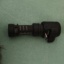 Černý kompaktní mikrofon s kovovou mřížkou. Na těle je bílý nápis VideoMic Me-C+ a pod ním MADE IN AUSTRALIA. Na pravé straně je viditelné sériové čí…