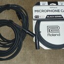 Černý mikrofonní kabel s XLR konektory, sbalený do dvou smyček. Vedle kabelu je bílé originální balení s nápisy MICROPHONE CABLE, BLACK SERIES, Rolan…