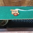 Detail vnitřní části klavíru s zeleným plýšovým potahem. Na povrchu je připevněna papírová štítková visačka s nápisy ORIGINAL PETROF a číslem 1864, d…