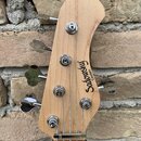 Fotografie zachycuje hlavu basové kytary z přírodního světlého dřeva. Na povrchu je černý nápis Sadowsky Guitars. Nástroj má čtyři chromované ladičky…