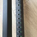 Detailní pohled na černý napájecí distribuční systém s řadou zelených kontrolních LED diod. U jednotlivých výstupů jsou uvedeny nápisy 9/12/18V 500mA…