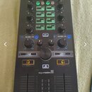Černý DJ kontrolér s nápisem MDD-10R v horní části a logem algoriddim ve spodní polovině. Zařízení obsahuje několik otočných knoflíků, posuvníků a řa…