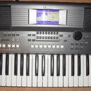 Černý digitální klavír značky YAMAHA s bílými a černými klávesami. V horní části je umístěn modrý displej s texty MAIN, Concert Grand a dalšími param…