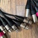 Skupina černých audio kabelů s kovovými konektory typu XLR. Na jednom z kabelů je nápis sssnake a webová adresa www.the. Na dvou konektorech jsou nal…