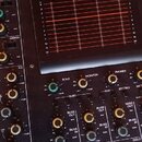 Detailní pohled na černý mixážní pult s nápisem Fostex MODEL 450. V horní části je displej s červeným mřížkovým grafem a kontrolkami POWER a SOLO. Sp…