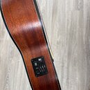 Detailní pohled na hnědý dřevěný korpus akustické kytary s černým lemováním. Na boku je umístěn ovládací panel s nápisem Carl Craig, který obsahuje t…
