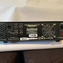 Zadní strana černého zesilovače značky Ashdown. Jsou zde vidět konektory SPEAKER OUT, LINE IN, FX SEND, FS-2 OUT, FX RTN a DI OUT, dále vstup MAINS s…