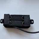Černý elektrický snímač s dvěma řadami magnetů a viditelnými kovovými póly. Snímač je zakončen černým kabelem a má na horní i dolní straně montážní ú…
